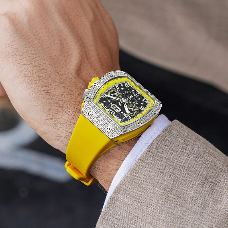 The gem-set tonneau watch worn on a yellow rubber strap